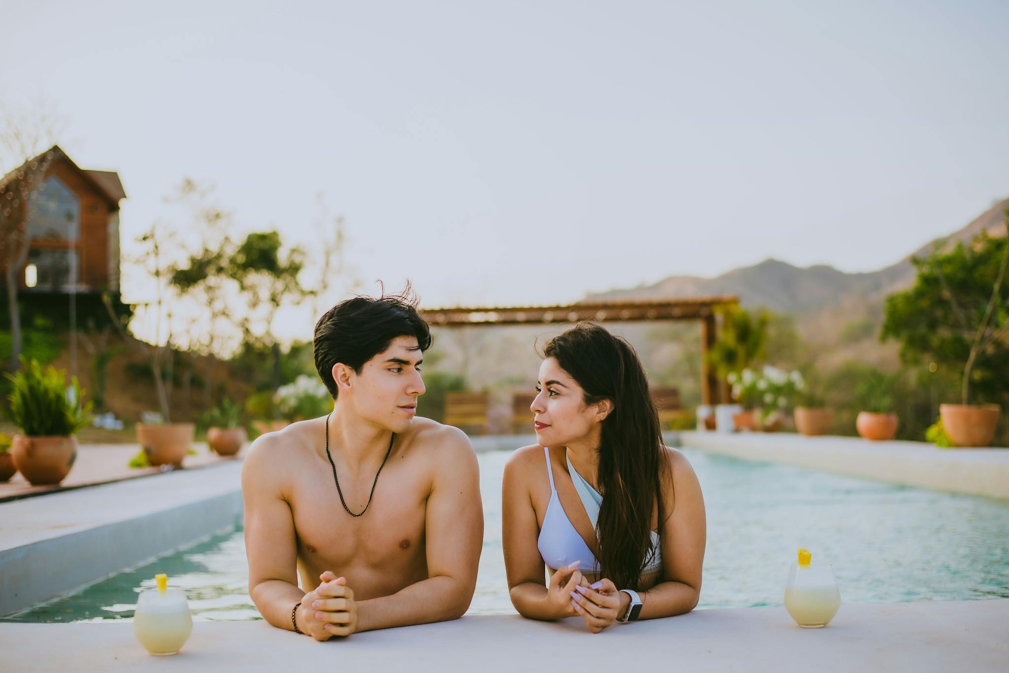 A couple enjoys a relaxing day at a resort pool, capturing summer vibes and tranquility.