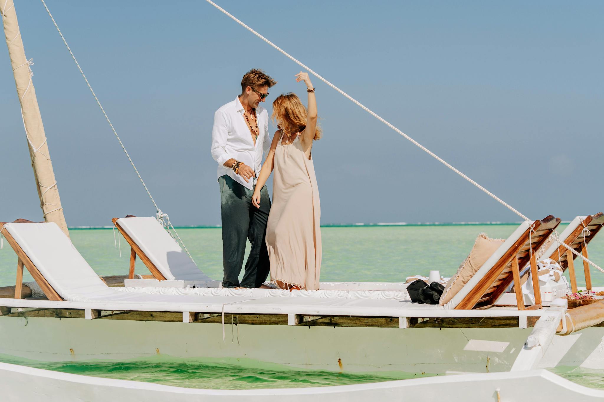 Couple enjoying a romantic sail on a dhow boat in Zanzibar's turquoise waters.